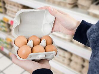 person buying eggs in supermarket